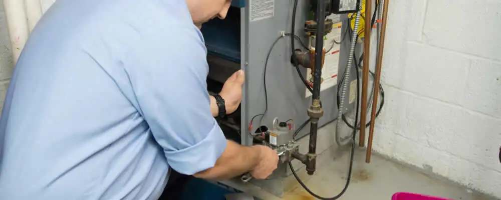 Furnace repair technician inspecting and servicing a home heating system in Modesto, CA