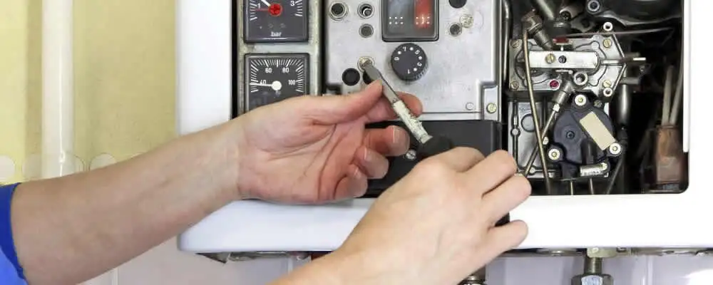 Heating repair technician adjusting boiler controls and components in Modesto, CA
