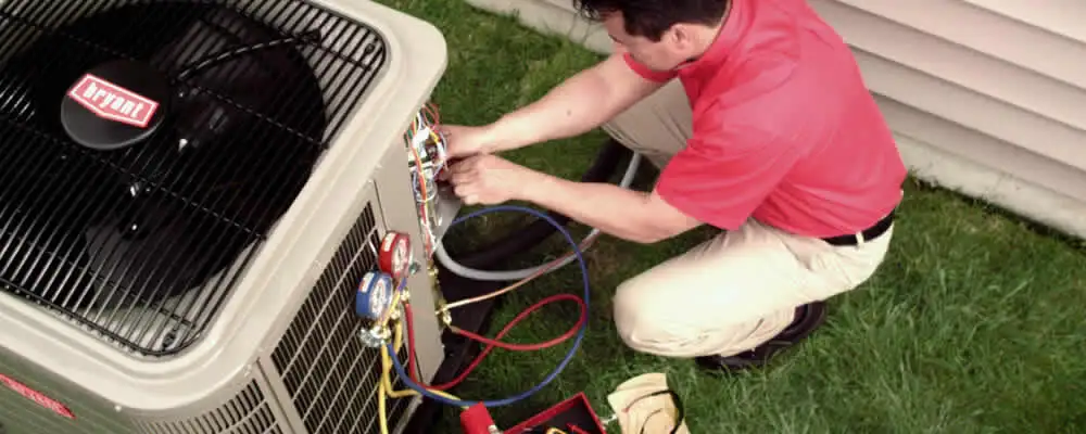 HVAC technician servicing an outdoor air conditioner unit in Modesto, CA