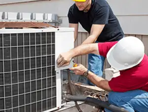 HVAC technicians repairing an outdoor AC unit on a rooftop in Modesto, CA