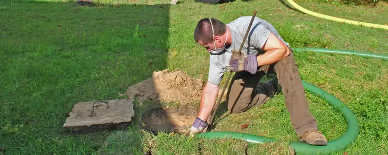 Septic pumping technician servicing a residential septic tank in Modesto, CA