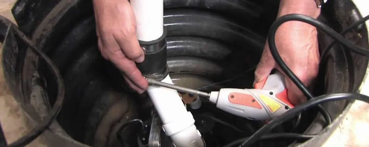 Sump pump installation technician connecting PVC discharge piping in Modesto, CA
