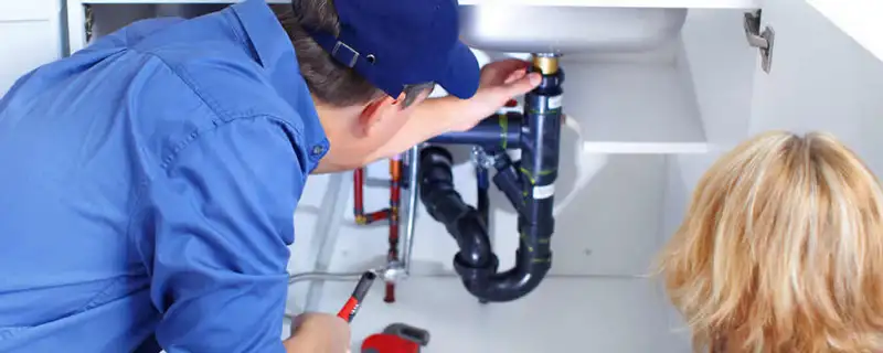 Plumber repairing under-sink drain pipes and fittings in Modesto, CA